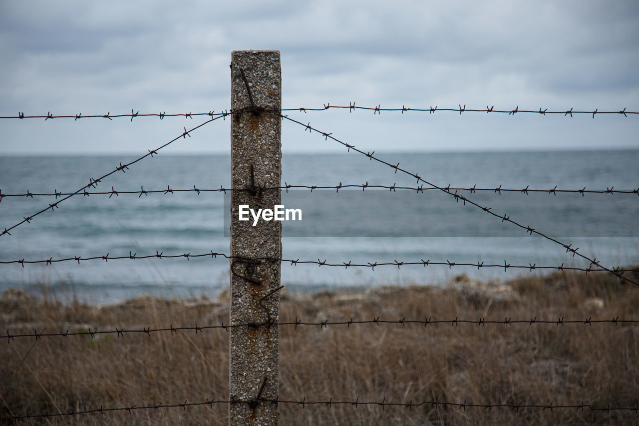 Travel restrictions. the sea beyond the fence with barbed wire