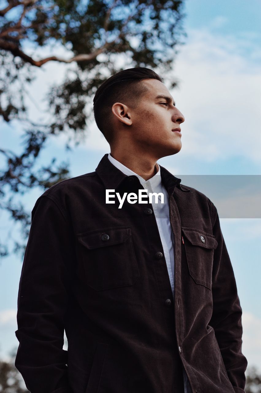 Thoughtful man standing against sky