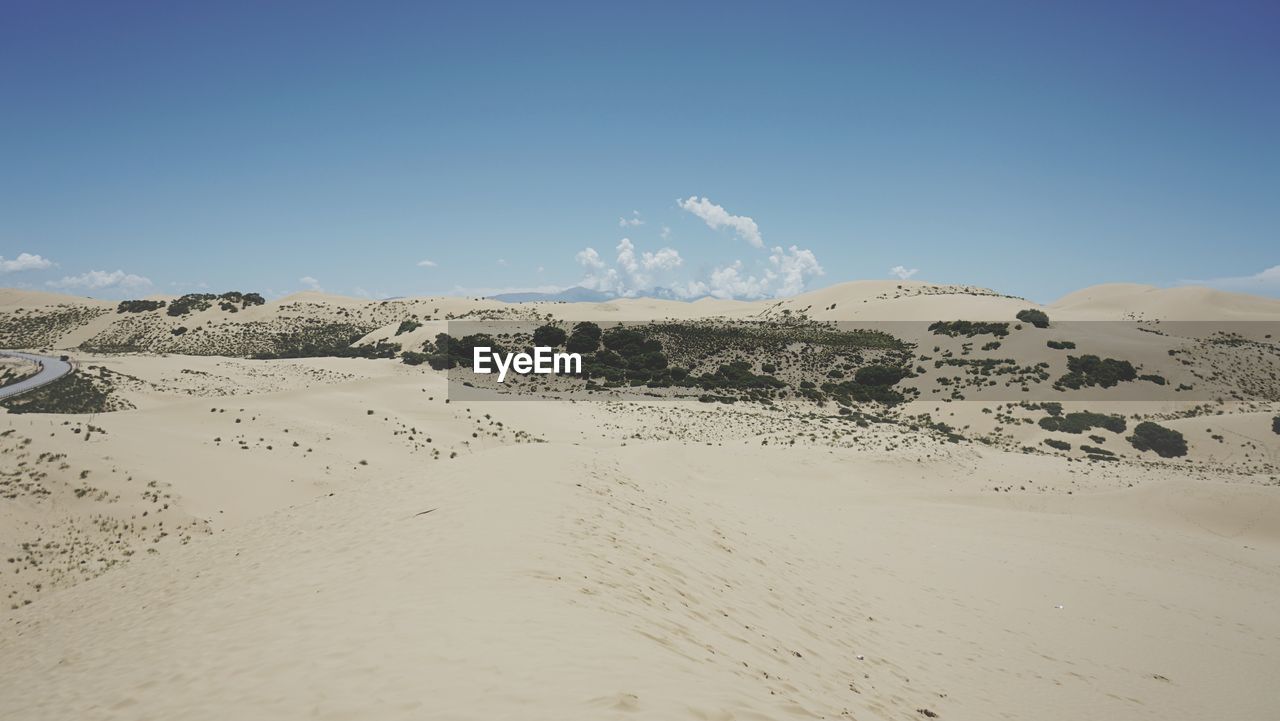 PANORAMIC SHOT OF SAND DUNE AGAINST SKY