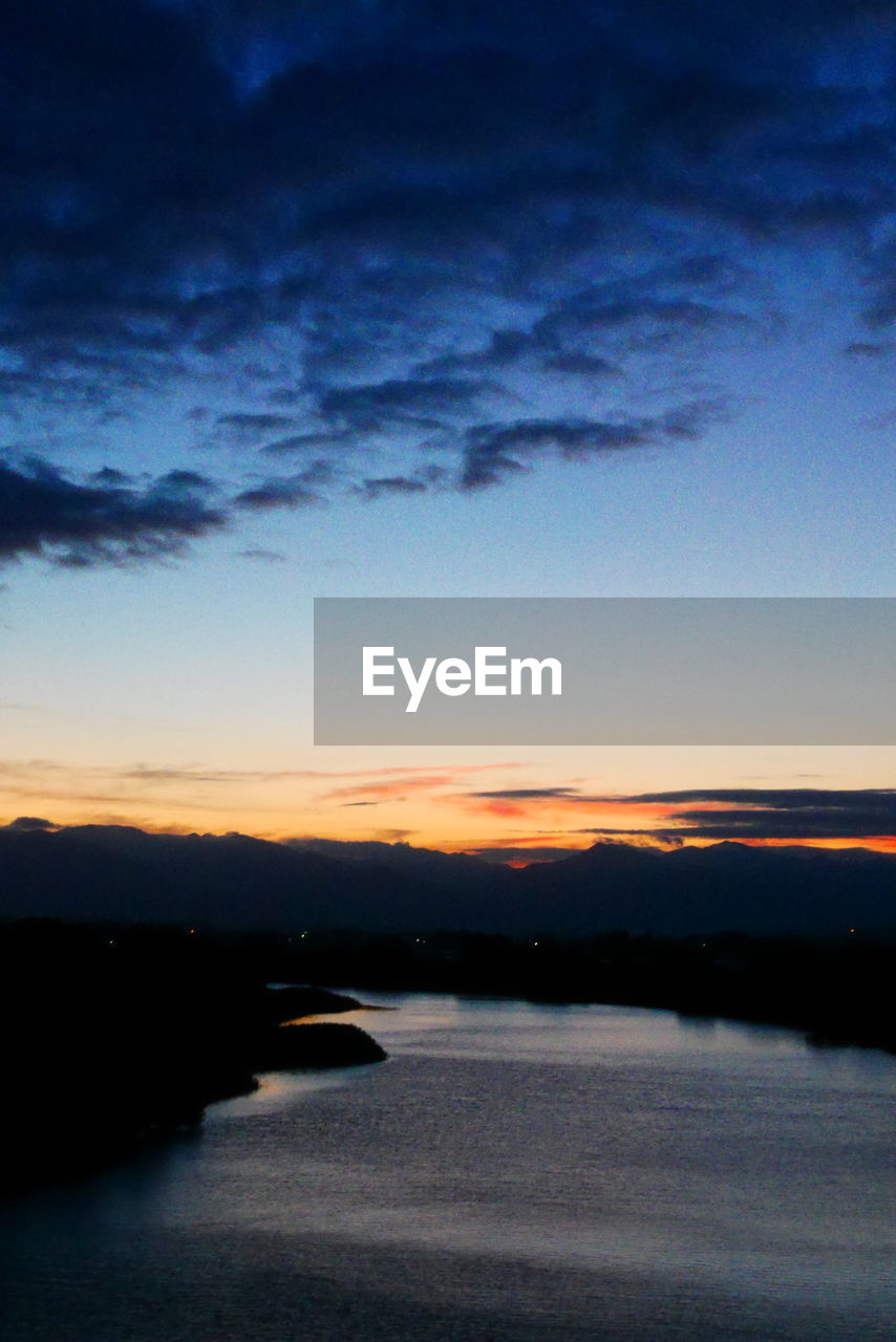 SCENIC VIEW OF LAKE AGAINST ORANGE SKY