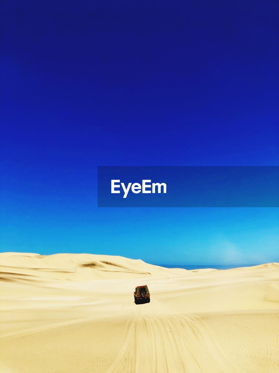 Scenic view of desert against clear blue sky