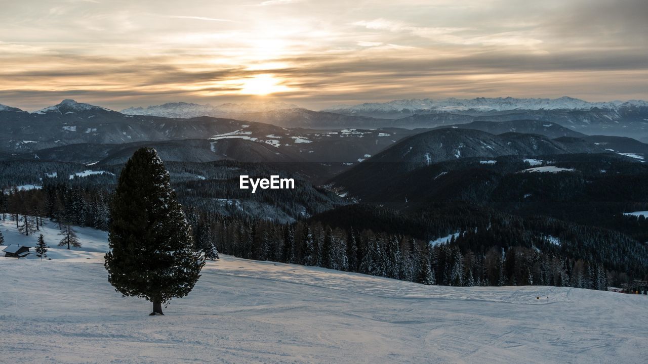 Scenic view of snow covered landscape against sky during sunset