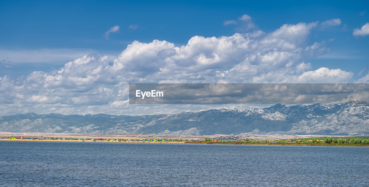 SCENIC VIEW OF SEA BY MOUNTAIN AGAINST SKY