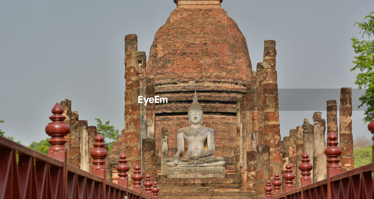 Statue in temple against sky