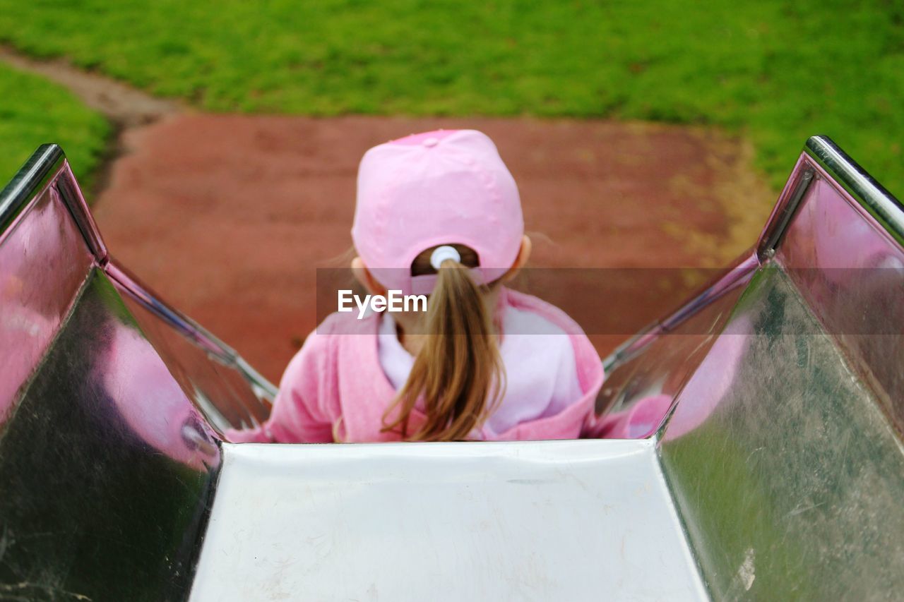 Rear view of girl on slide at playground