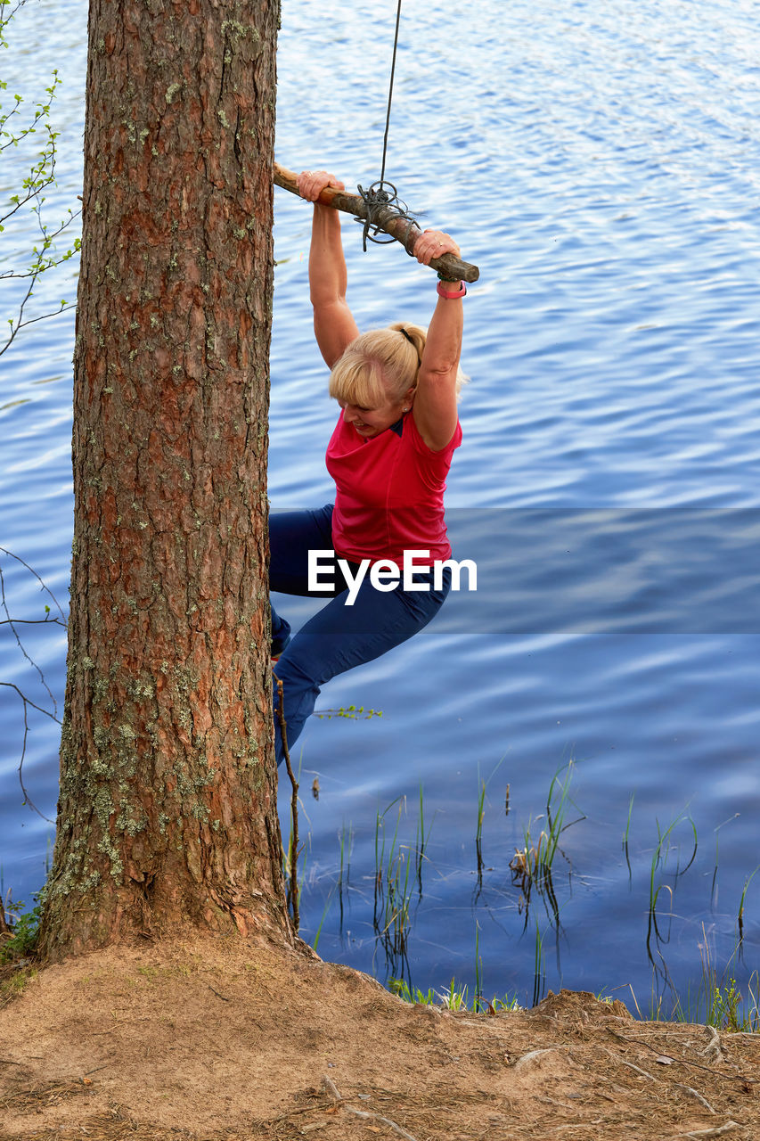 rear view of woman swinging on tree