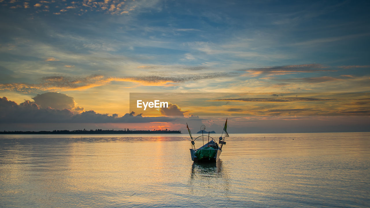 Boat moored on sea against sky during sunset