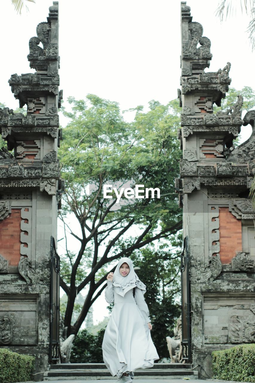 Portrait of woman standing at temple