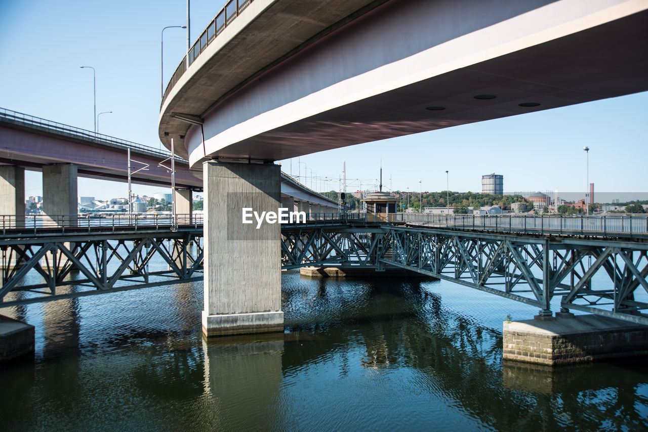 Bridge over river in city against sky