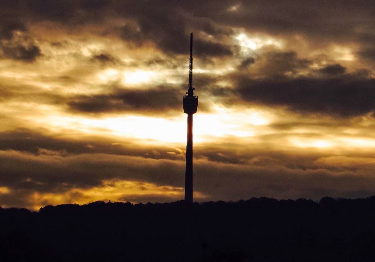 SILHOUETTE COMMUNICATIONS TOWER IN CITY AGAINST SKY