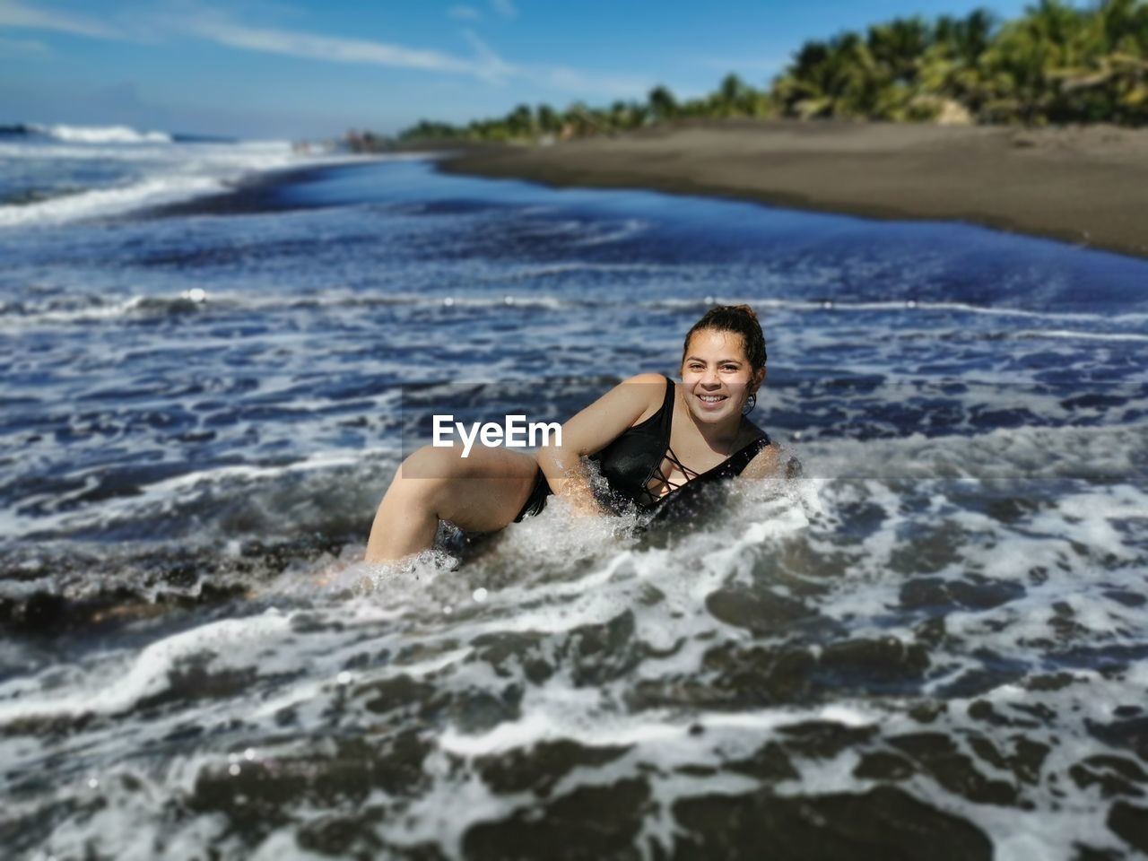 Portrait of young woman lying on beach