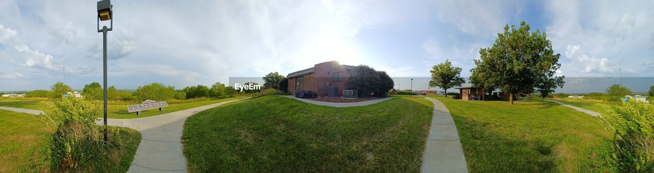 PANORAMIC SHOT OF ROAD AMIDST BUILDINGS AGAINST SKY