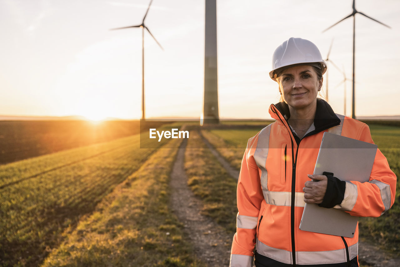 Smiling engineer with digital tablet at wind park