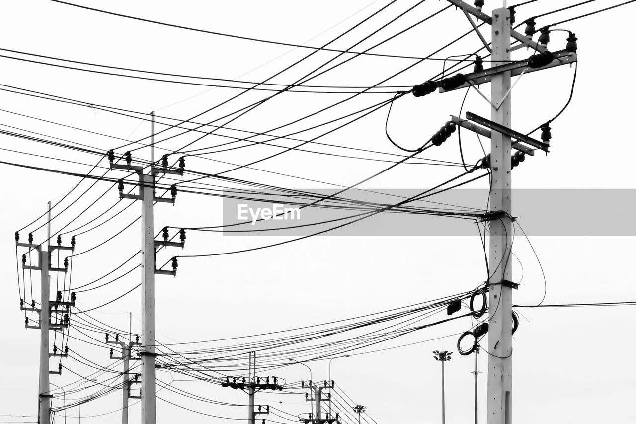 LOW ANGLE VIEW OF POWER LINES AGAINST CLEAR SKY