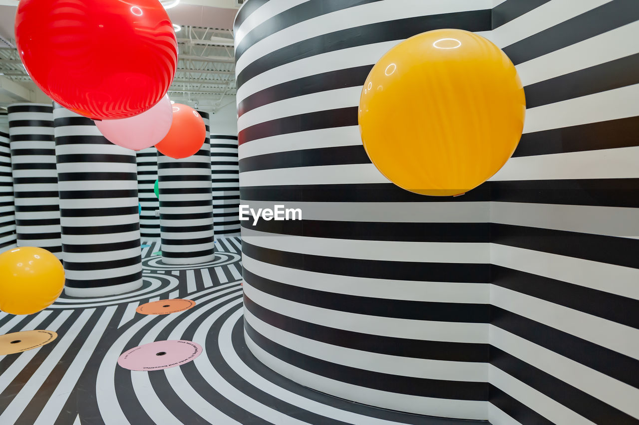 HIGH ANGLE VIEW OF MULTI COLORED BALLOON ON UMBRELLA