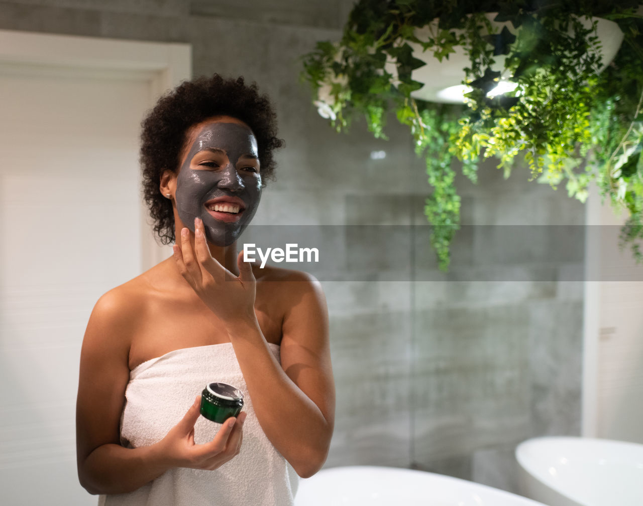 Cheerful african american woman applying mask