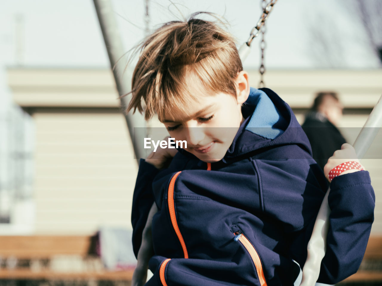 Boy playing on swing at playground