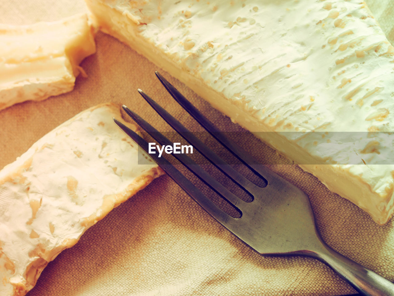 Close-up of cheese with fork on napkin