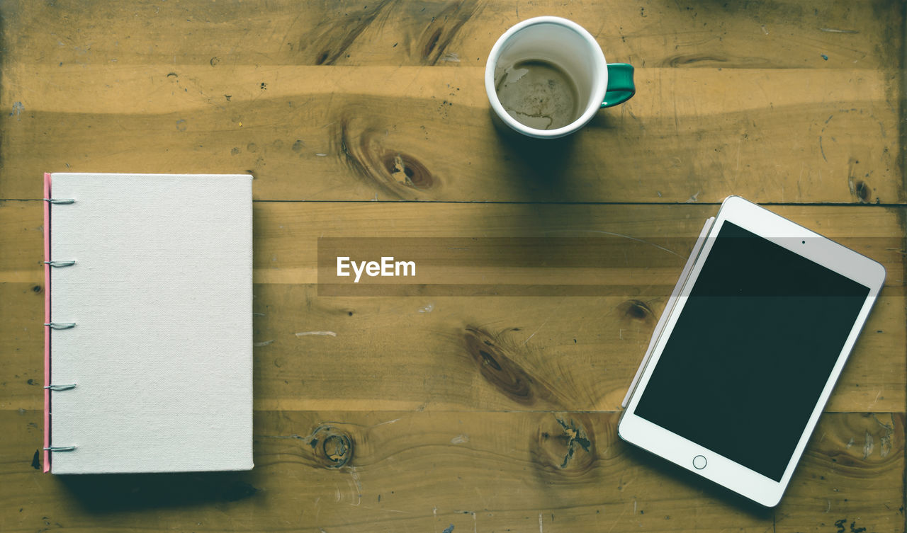 HIGH ANGLE VIEW OF COFFEE CUP WITH TEXT ON TABLE