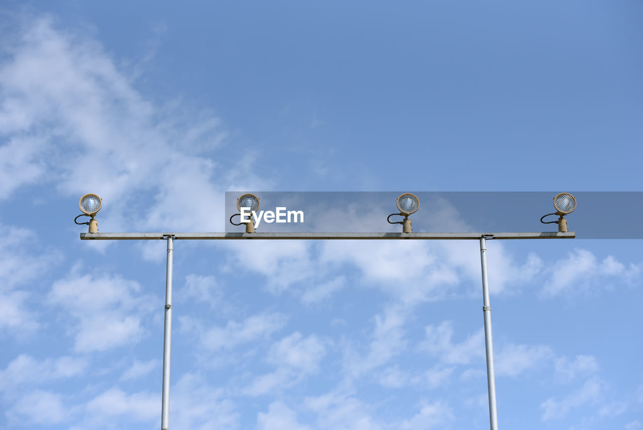 LOW ANGLE VIEW OF STREET LIGHTS AGAINST BLUE SKY