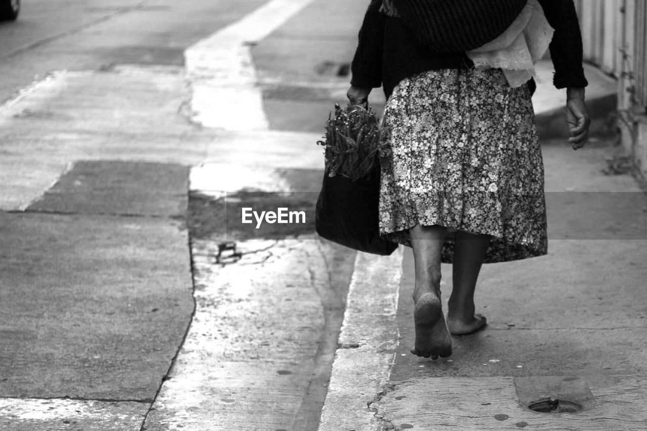 LOW SECTION OF WOMAN WALKING ON STREET