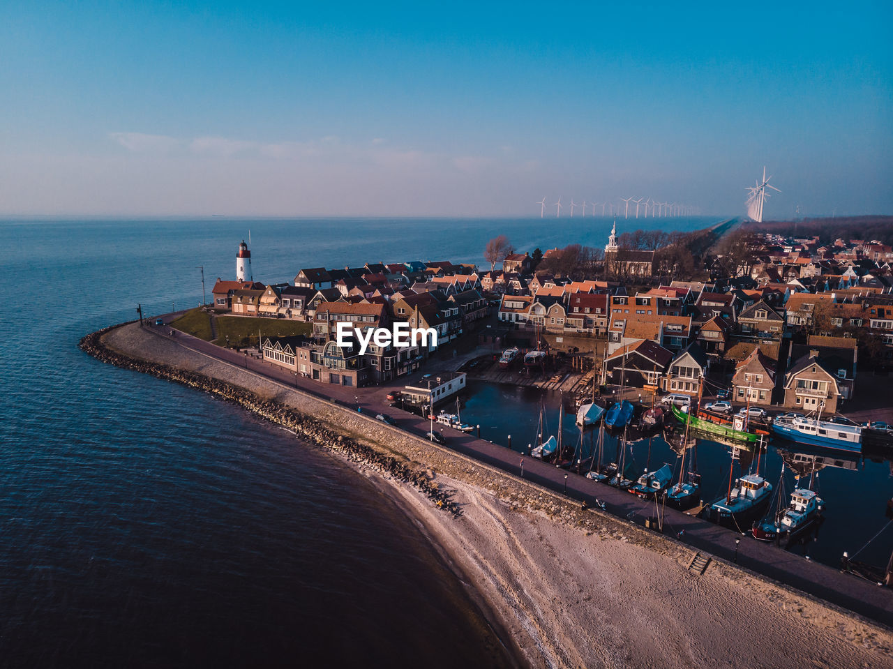 Aerial view of cityscape by sea against sky, lighthouse urk netherlands sunset