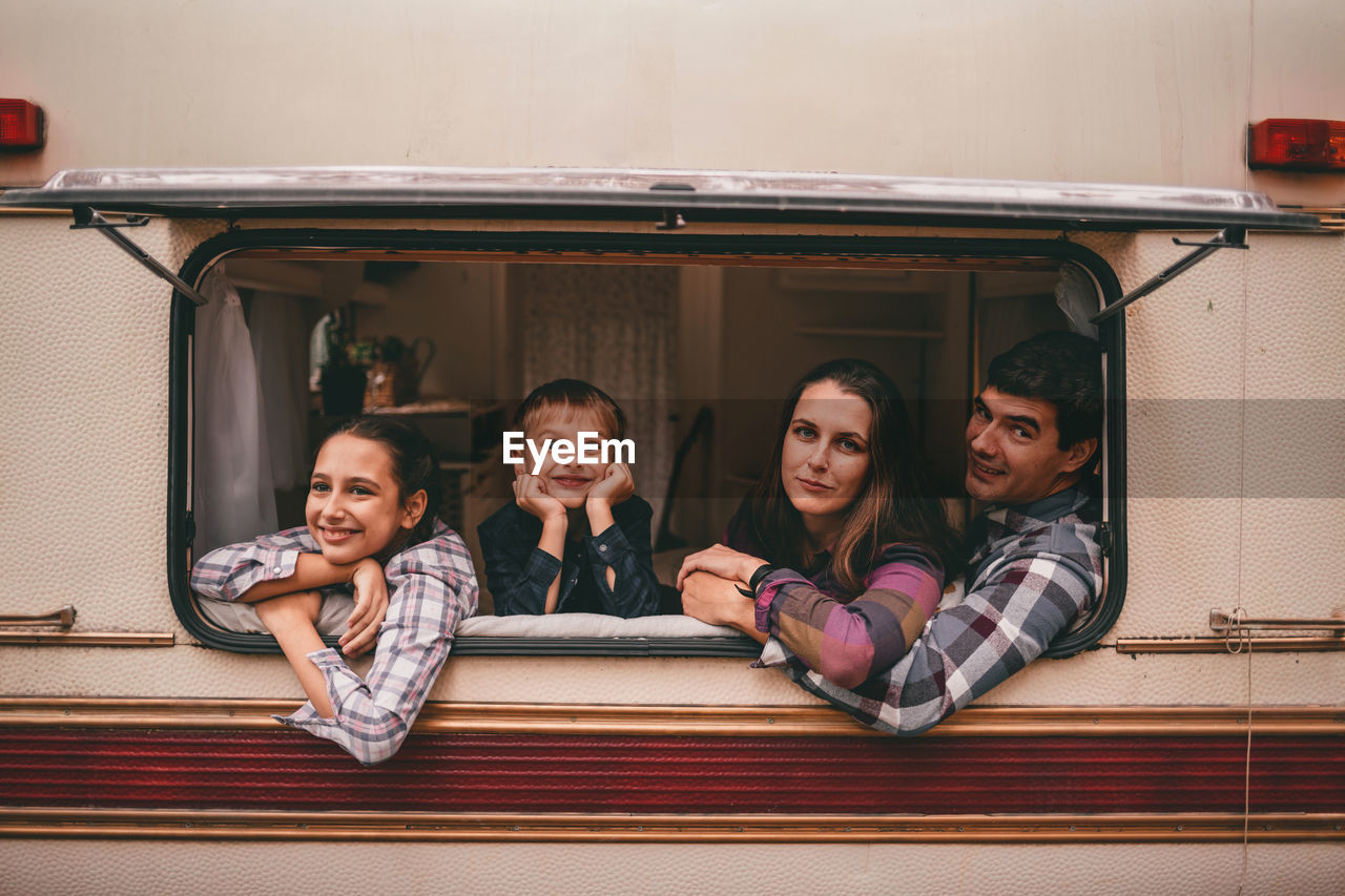 Happy family on camping trip relaxing in the autumn forest camper trailer fall season outdoors trip