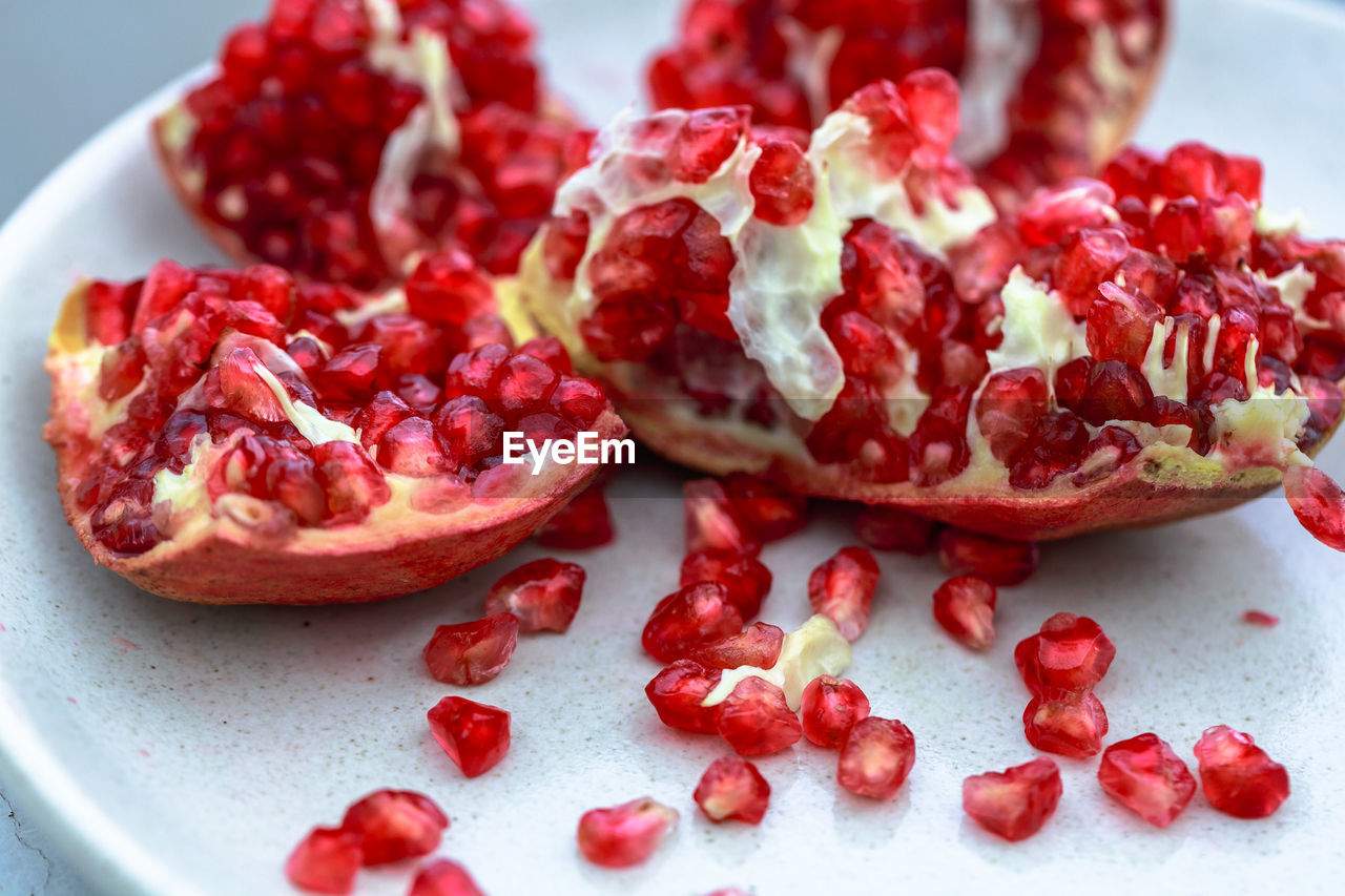 food and drink, pomegranate, food, healthy eating, fruit, plant, pomegranate seed, wellbeing, freshness, red, seed, produce, no people, berries, studio shot, berry, antioxidant, cranberry, close-up, plate, indoors, slice, cross section, sweet food, juicy, vitamin