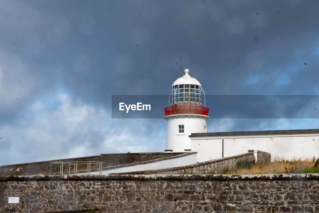 architecture, built structure, building exterior, lighthouse, tower, guidance, building, security, protection, sky, cloud, nature, sea, no people, coast, travel destinations, outdoors, travel, history, day, water, the past, beach, land, house, low angle view