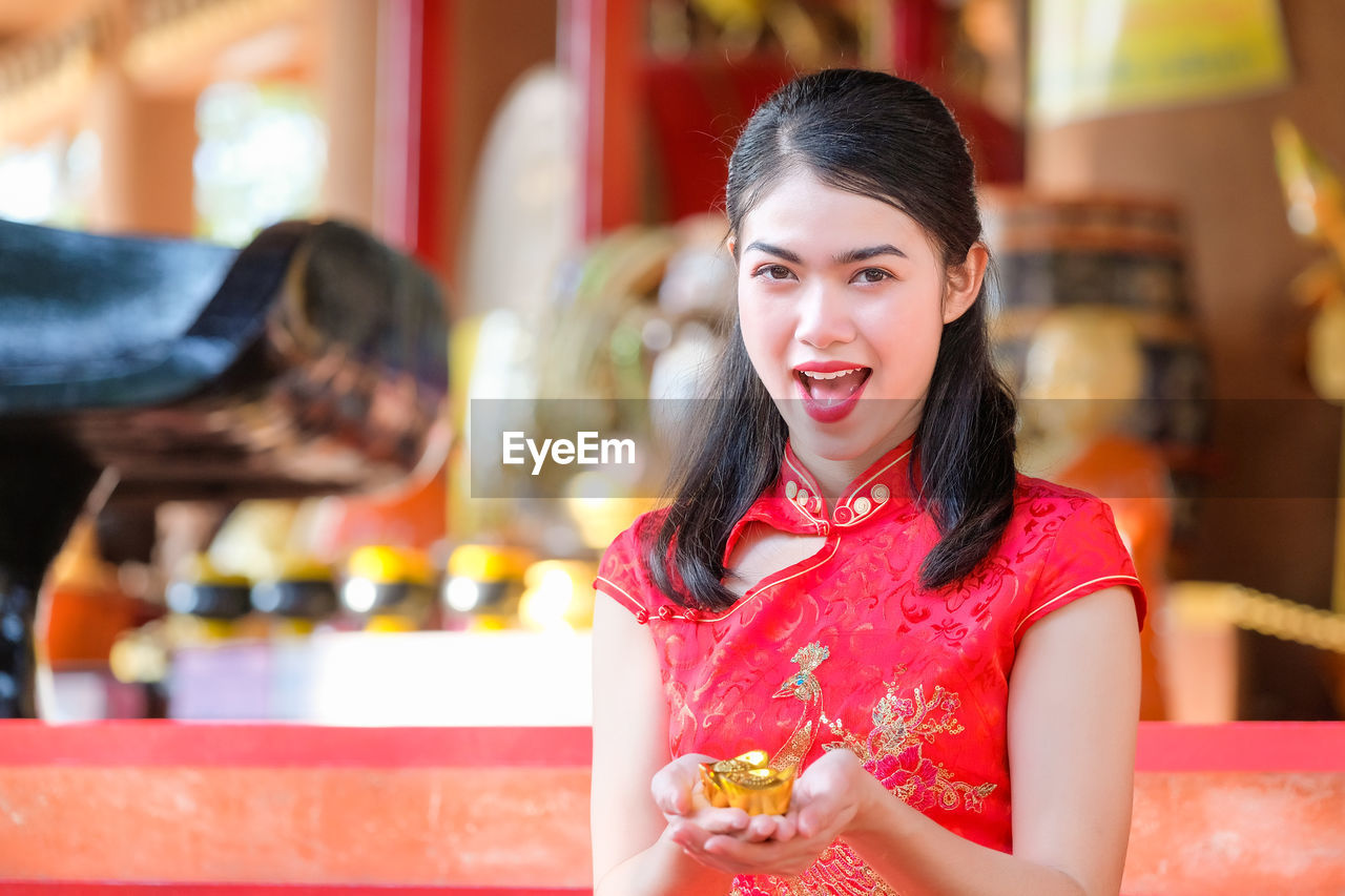 PORTRAIT OF A SMILING YOUNG WOMAN SITTING ON RESTAURANT