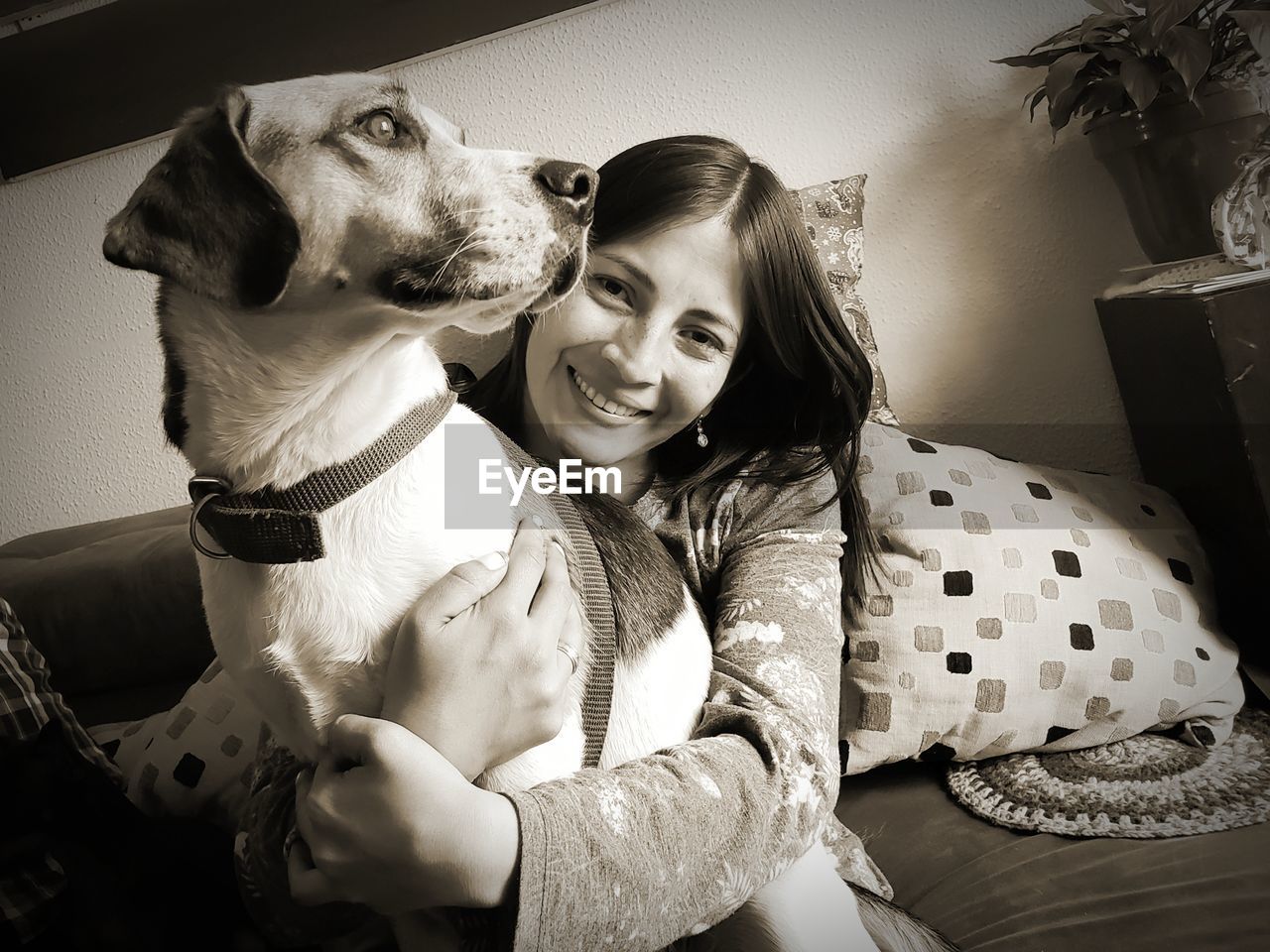 Portrait of smiling woman with dog at home