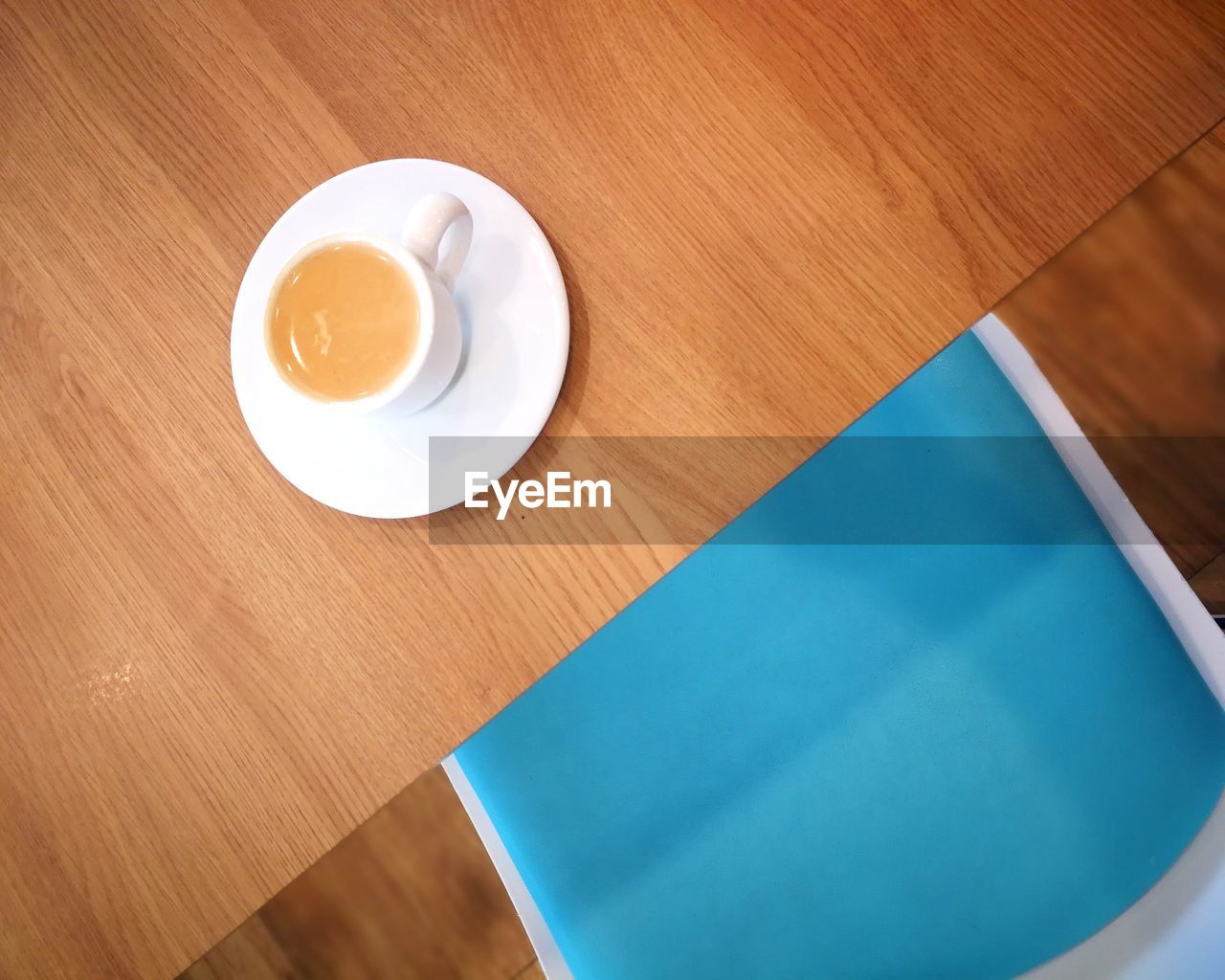 HIGH ANGLE VIEW OF COFFEE CUP ON TABLE WITH SPOON