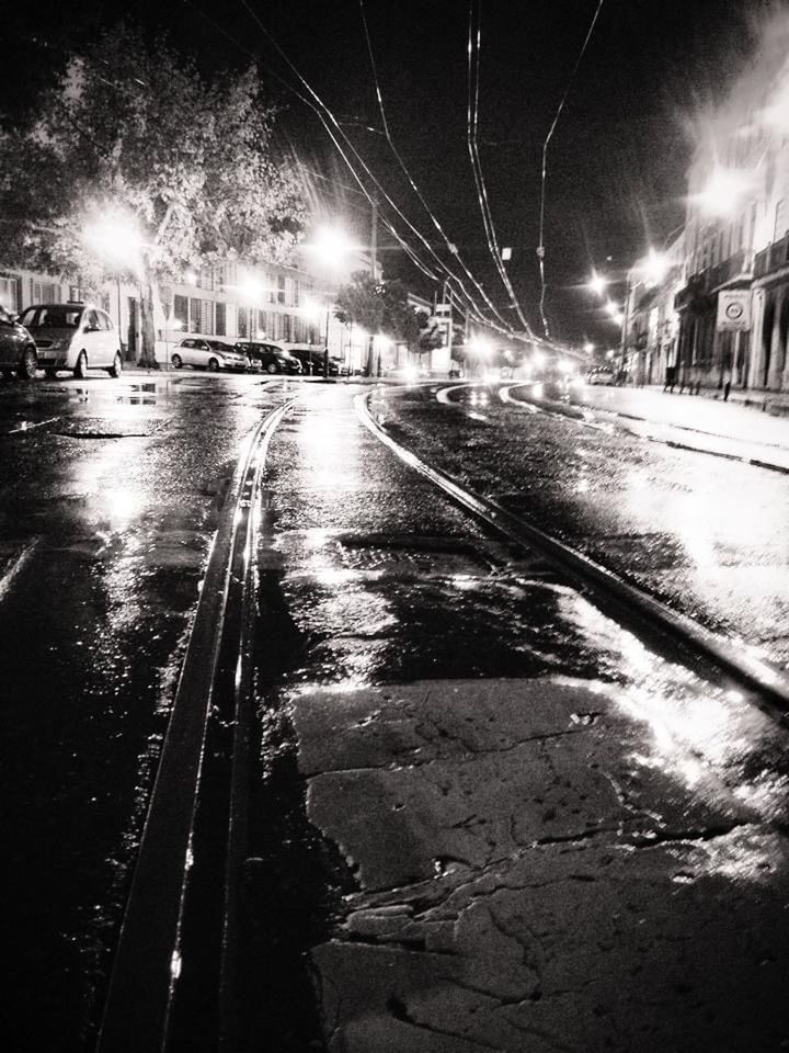 darkness, night, transportation, city, street, illuminated, road, mode of transportation, light, black and white, architecture, car, wet, motor vehicle, no people, nature, street light, monochrome, rain, monochrome photography, building exterior, the way forward, city street, land vehicle, built structure, water, outdoors, sky, motion, headlight, lighting equipment, snow, sign, city life, tree