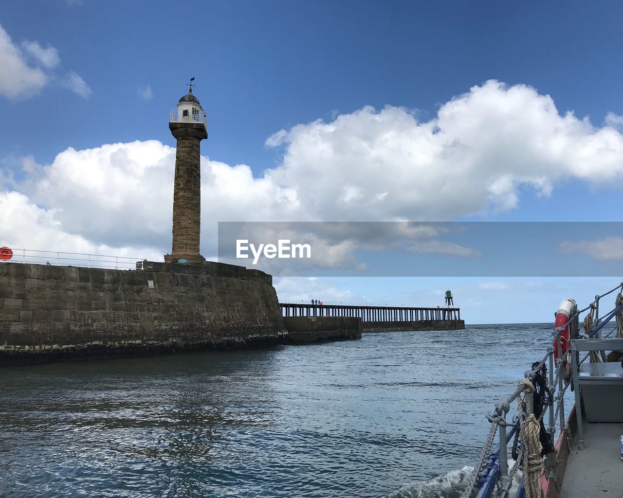 LIGHTHOUSE BY BUILDING AGAINST SKY