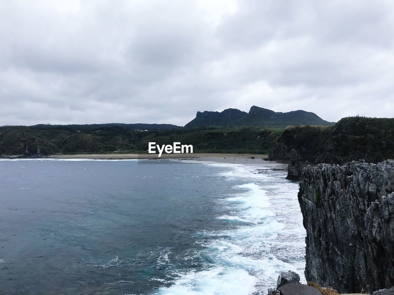 SCENIC VIEW OF SEA BY MOUNTAIN AGAINST SKY