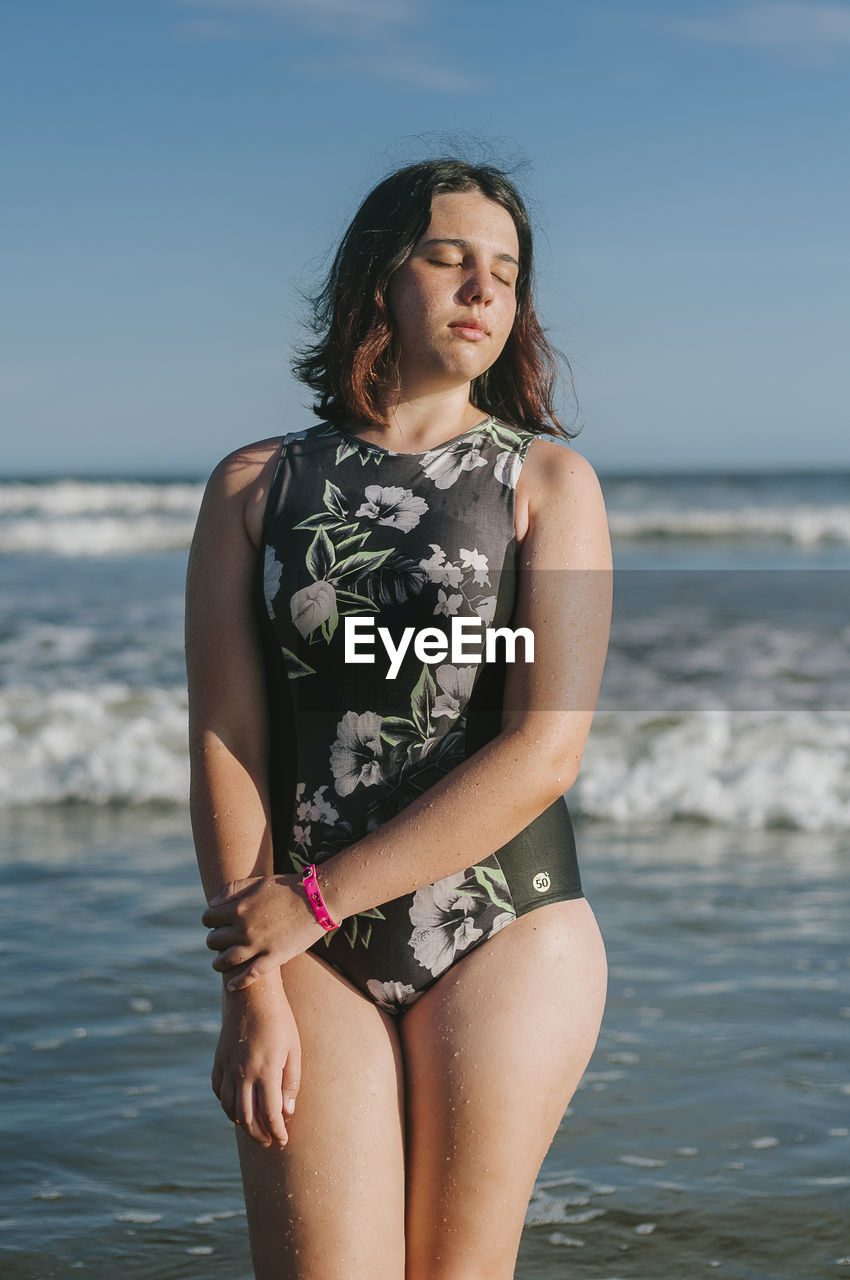 Woman with closed eyes standing at beach