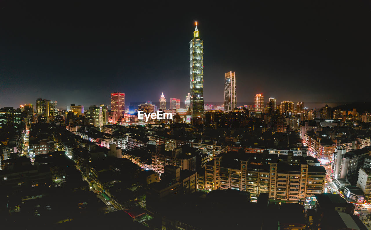 ILLUMINATED BUILDINGS AGAINST SKY AT NIGHT