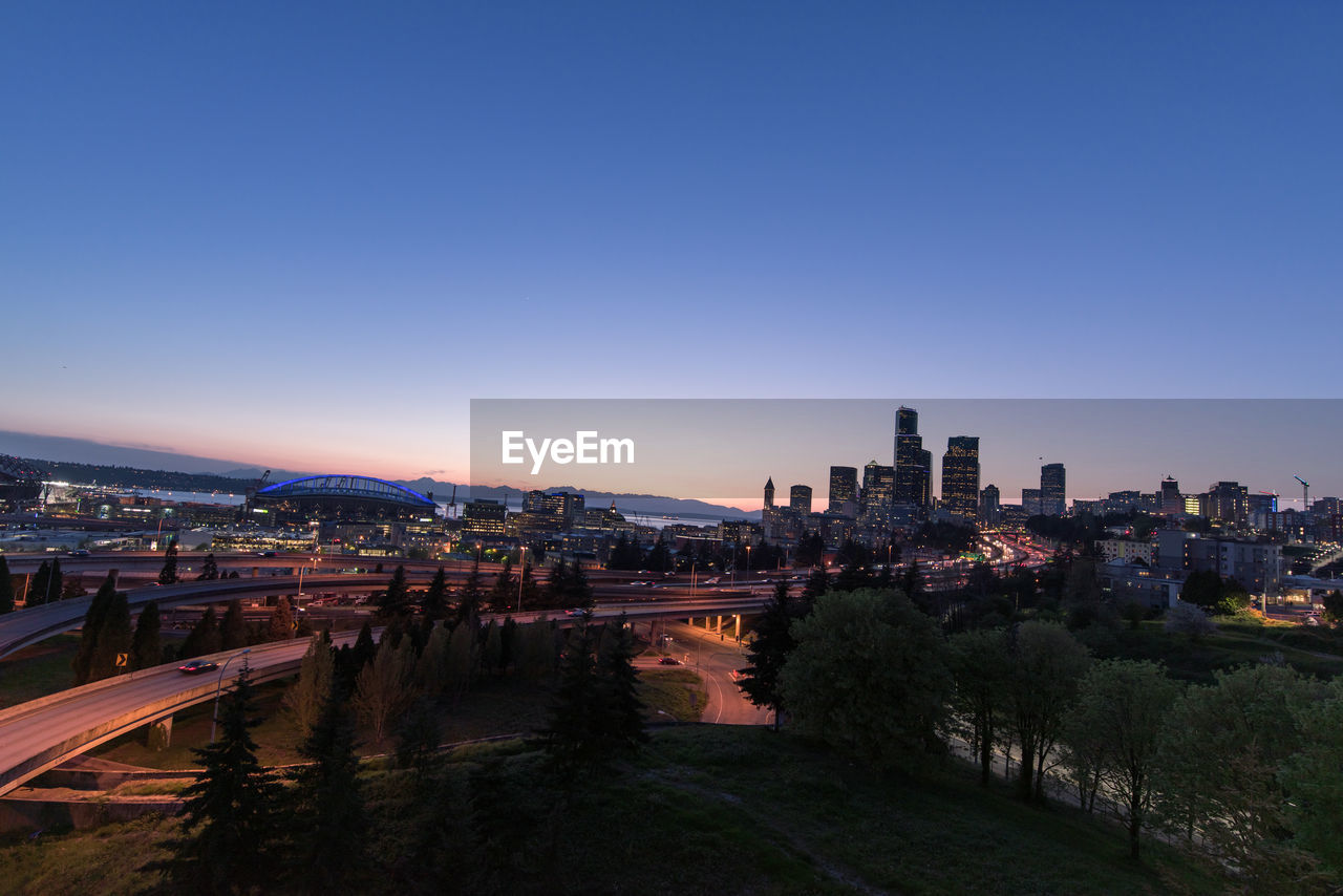 HIGH ANGLE VIEW OF CITY BUILDINGS AGAINST CLEAR SKY