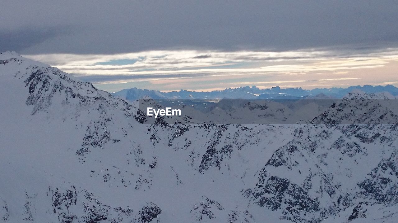 SCENIC VIEW OF MOUNTAINS AGAINST CLOUDY SKY