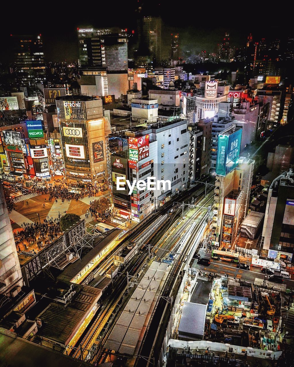 HIGH ANGLE VIEW OF ILLUMINATED CITY BUILDINGS AT NIGHT