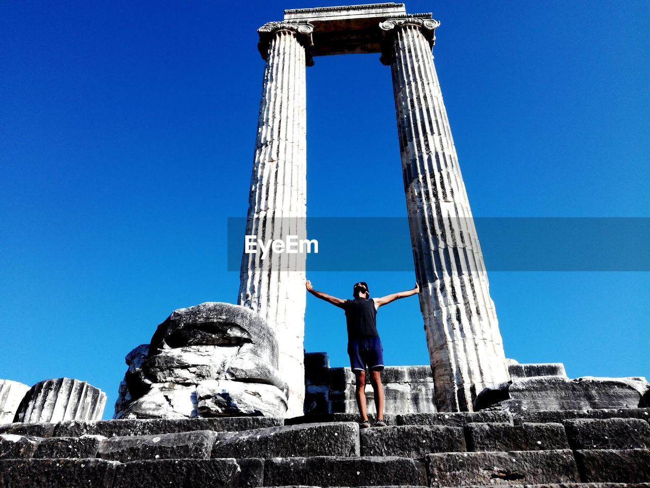 LOW ANGLE VIEW OF WOMAN STANDING AGAINST SKY