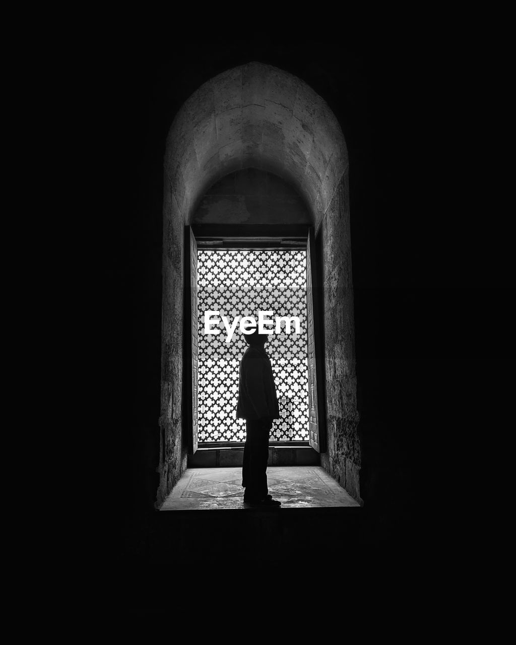 REAR VIEW OF SILHOUETTE WOMAN STANDING IN DARK ROOM