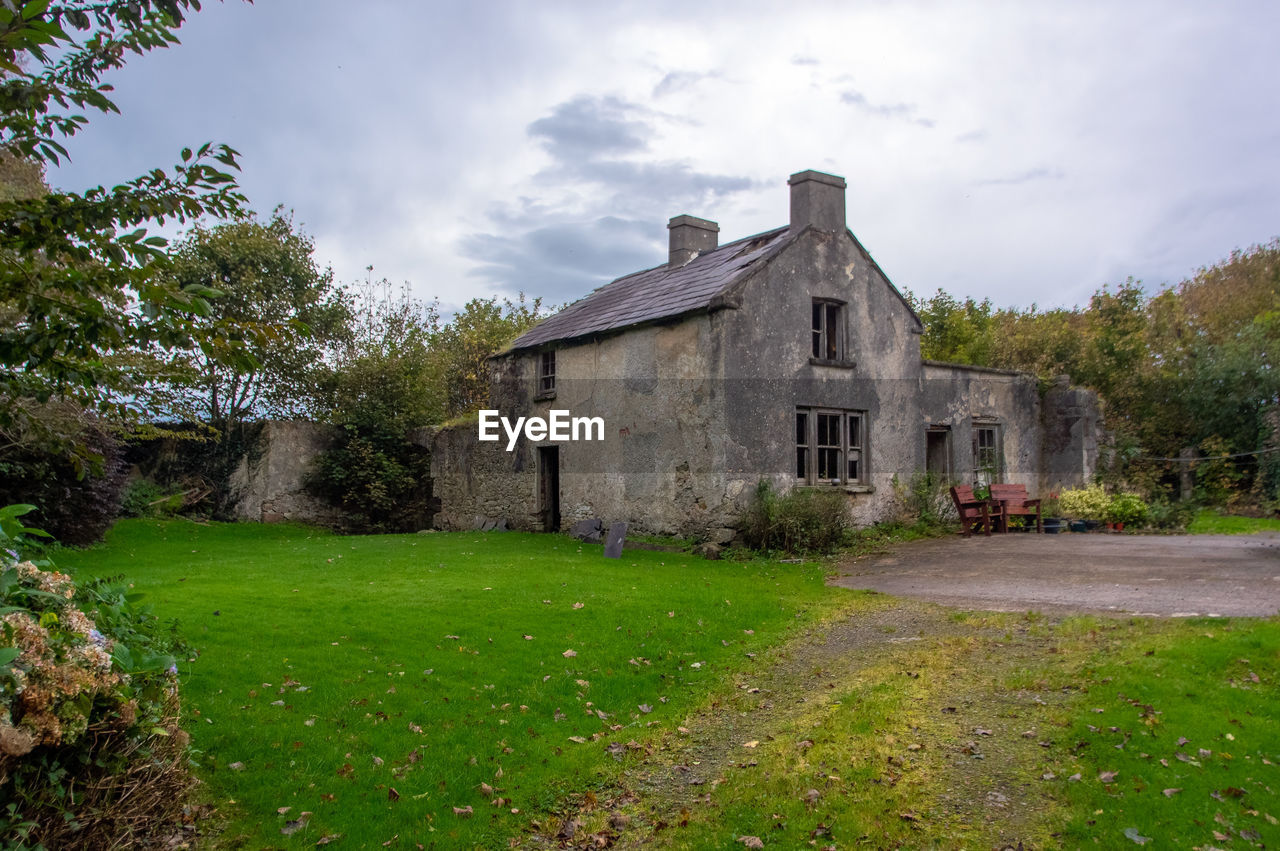 HOUSE ON FIELD AGAINST SKY