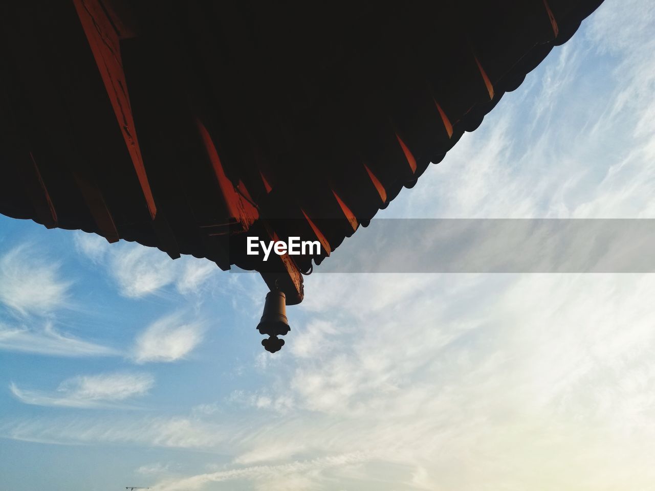 LOW ANGLE VIEW OF MAN FLYING HANGING FROM ROOF