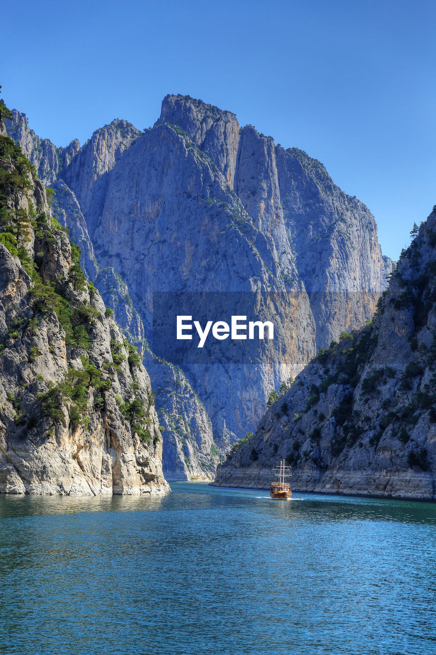 Scenic view of sea and mountains against blue sky