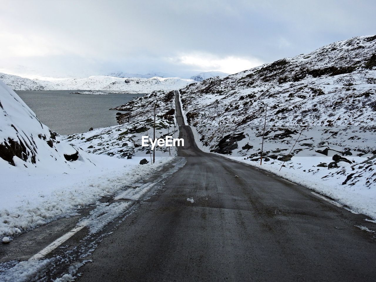 Road amidst snowcapped mountains against sky