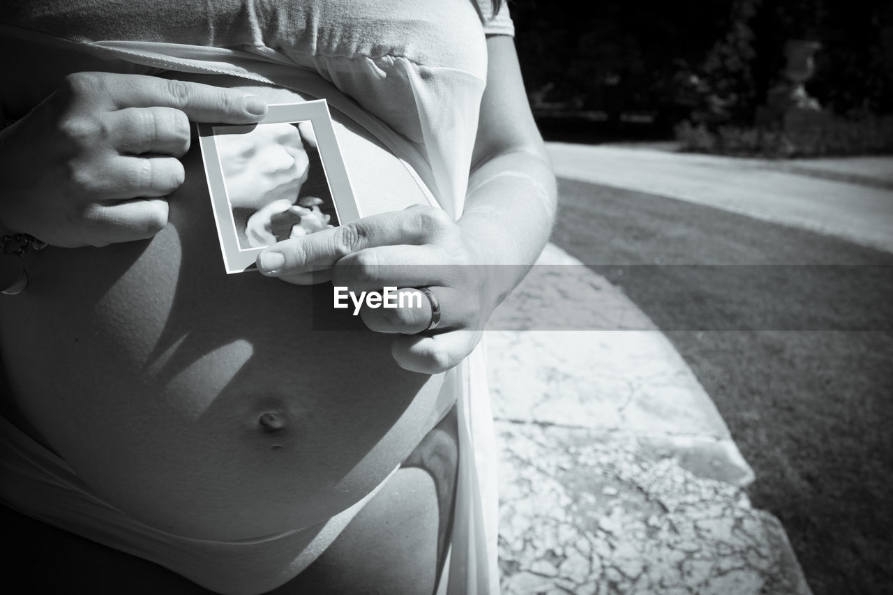 white, black, adult, black and white, one person, women, person, hand, monochrome photography, clothing, monochrome, holding, midsection, pregnant, day, lifestyles, focus on foreground, nature, child, outdoors, close-up