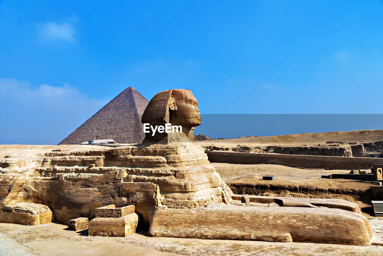Side view of the sphinx against pyramid in egypt