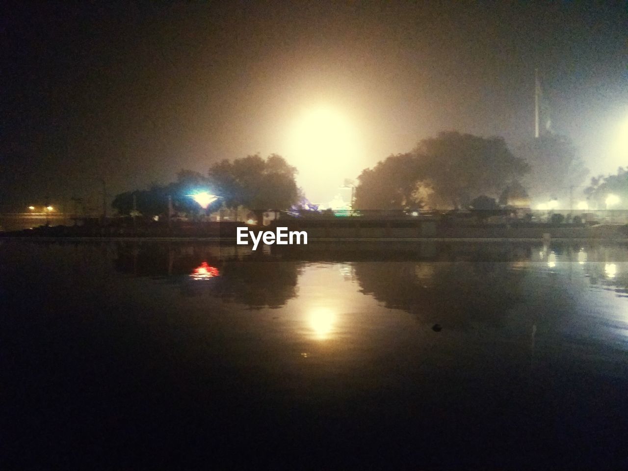 ILLUMINATED CITY BY WATER AT NIGHT