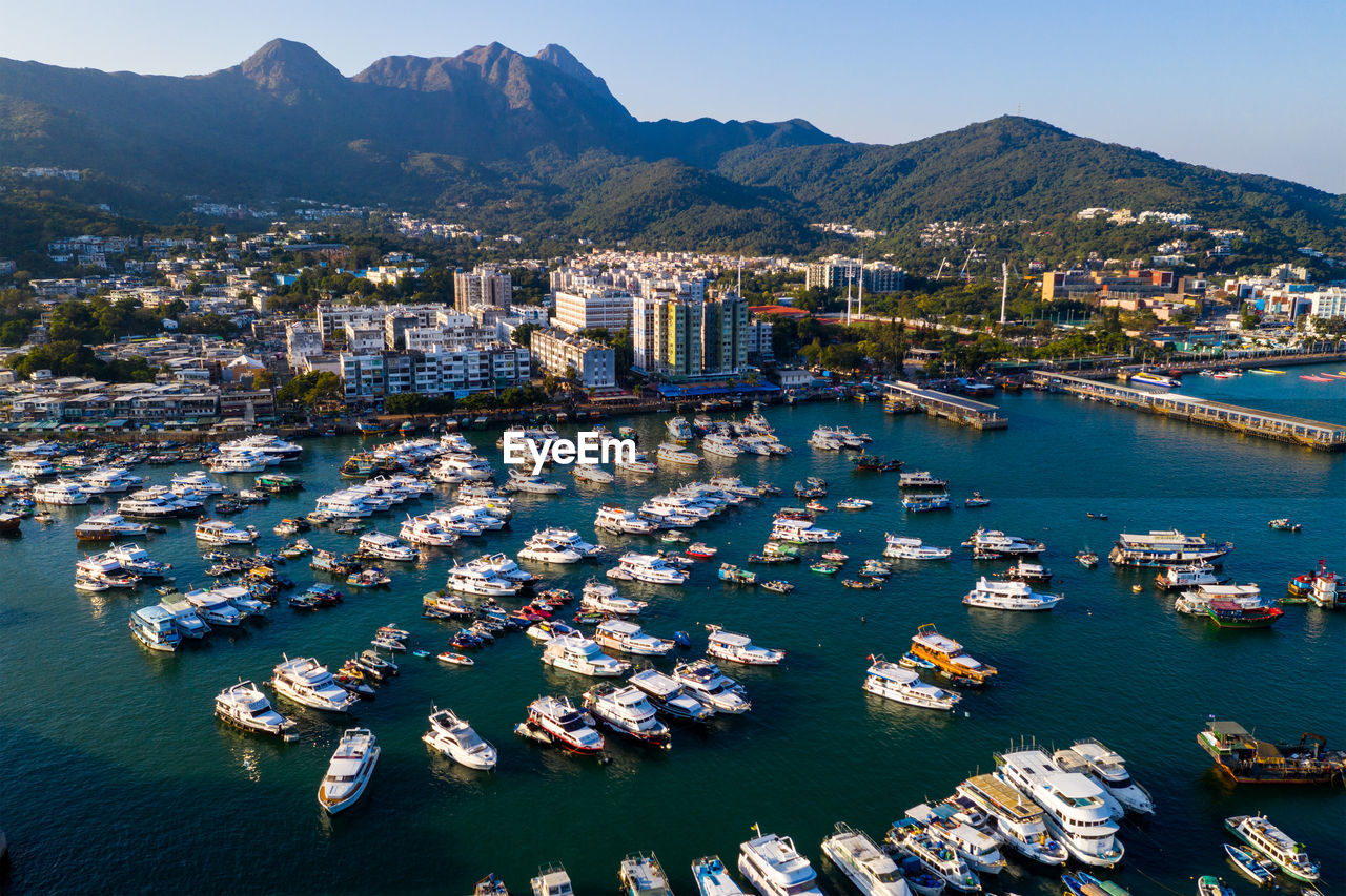 Aerial view of boats moored in sea by townscape